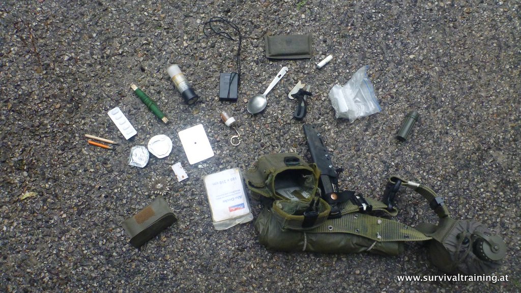 Komplette Survival-Ausrüstung ausgelegt: Messer, Kompass, Erste-Hilfe-Set, Rucksack
