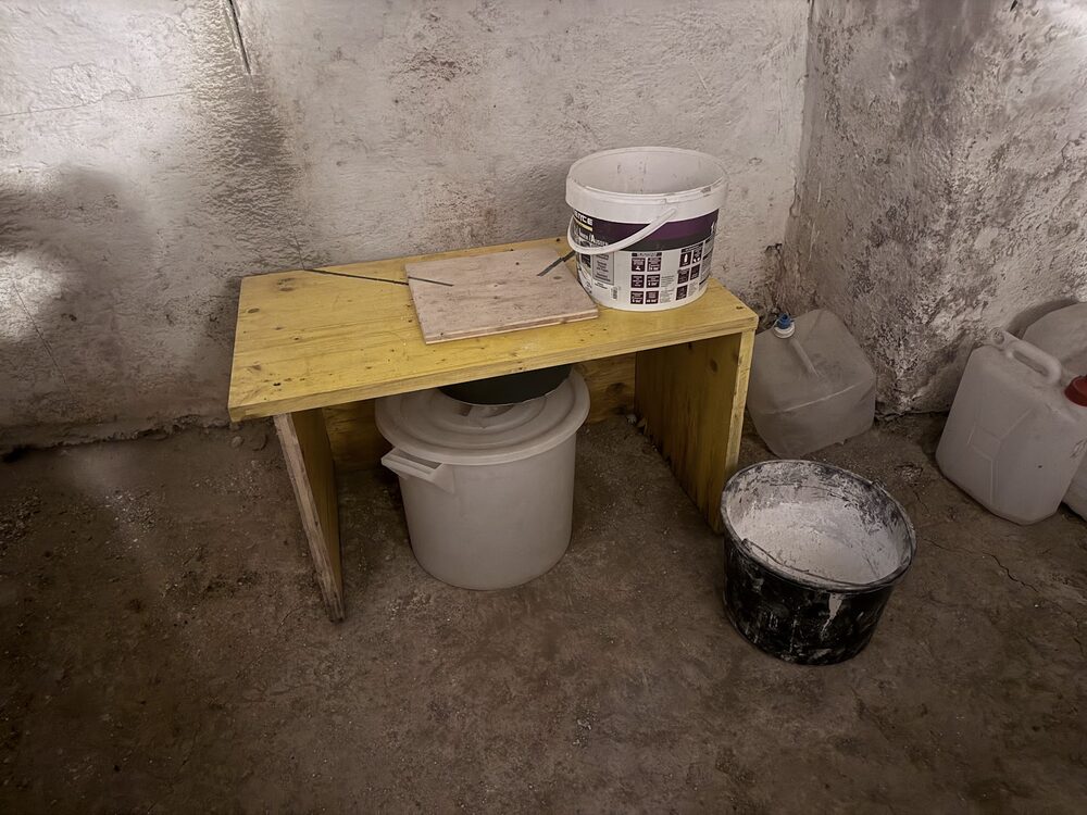 Vorratsbehälter und Kompostklo im Prepper-Keller