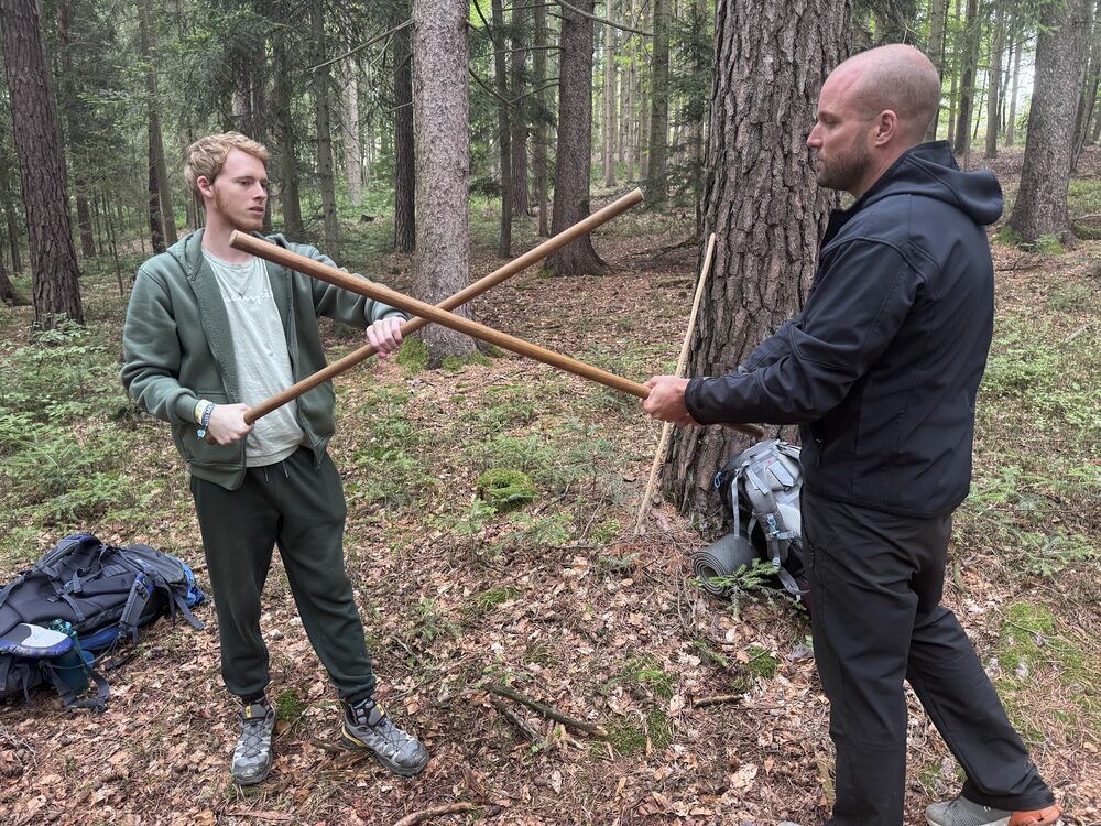 Zwei Teilnehmer beim Stocktraining im Wald